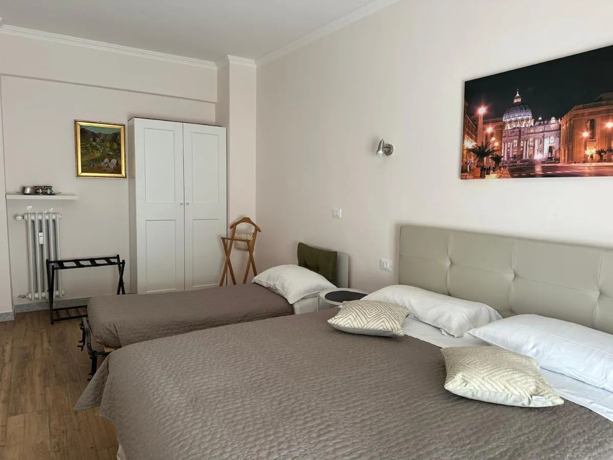 Camera con letto matrimoniale, letto singolo e quadro di San Pietro di notte
