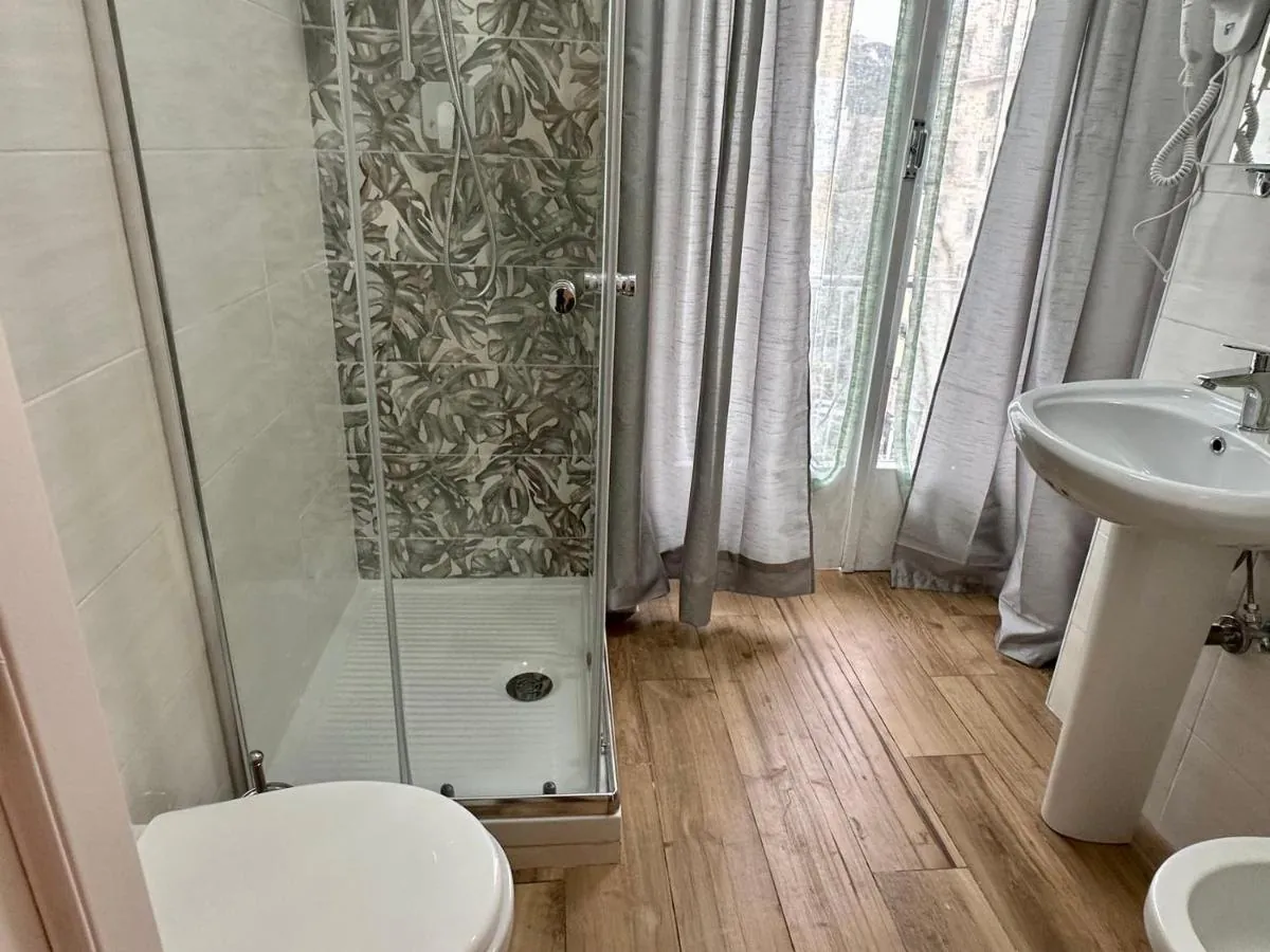 Bagno privato con doccia e lavabo, piastrelle a foglie