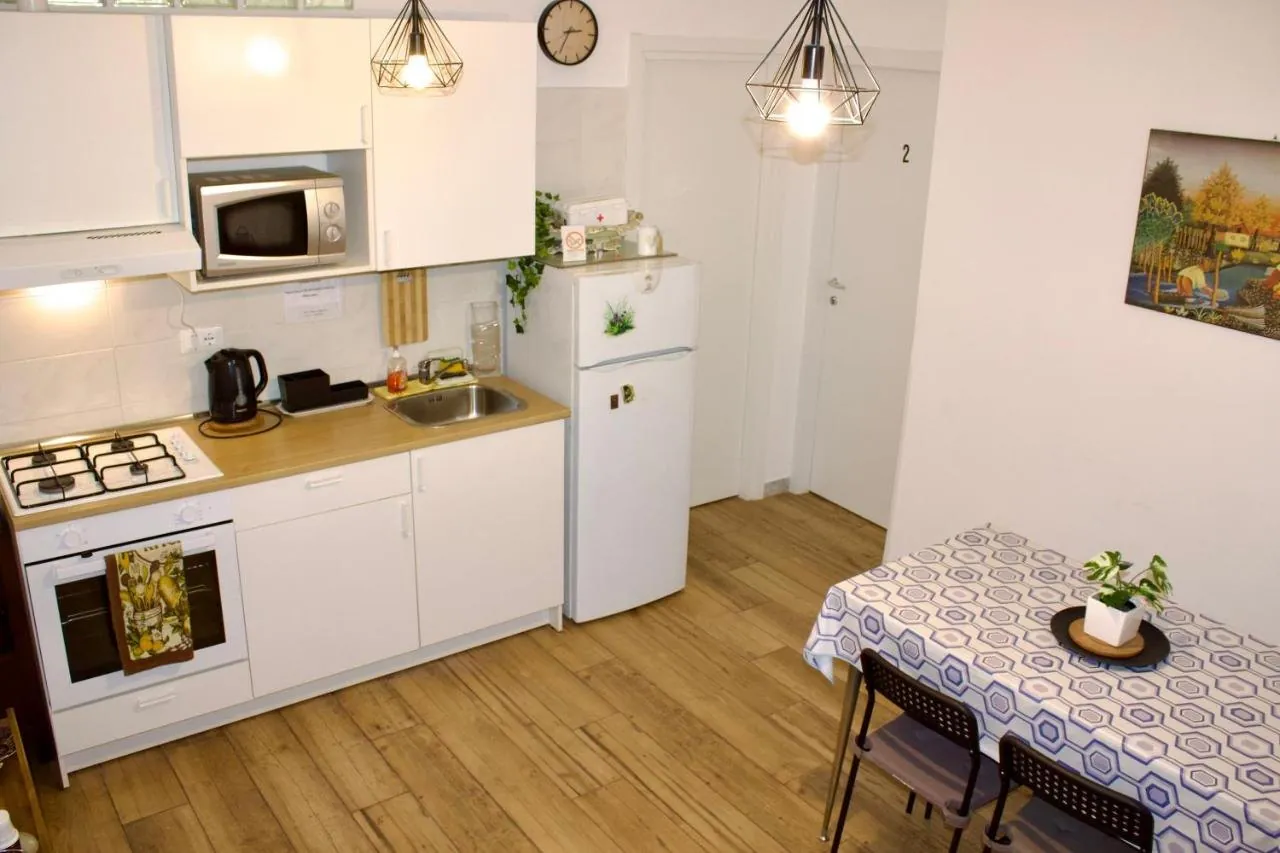La cucina in comune con frigorifero, piano cottura, microonde e un tavolo apparecchiato