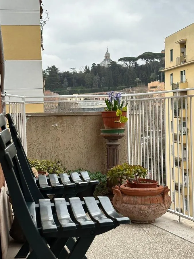 Il balcone con sedie pieghevoli e la cupola di San Pietro in lontananza