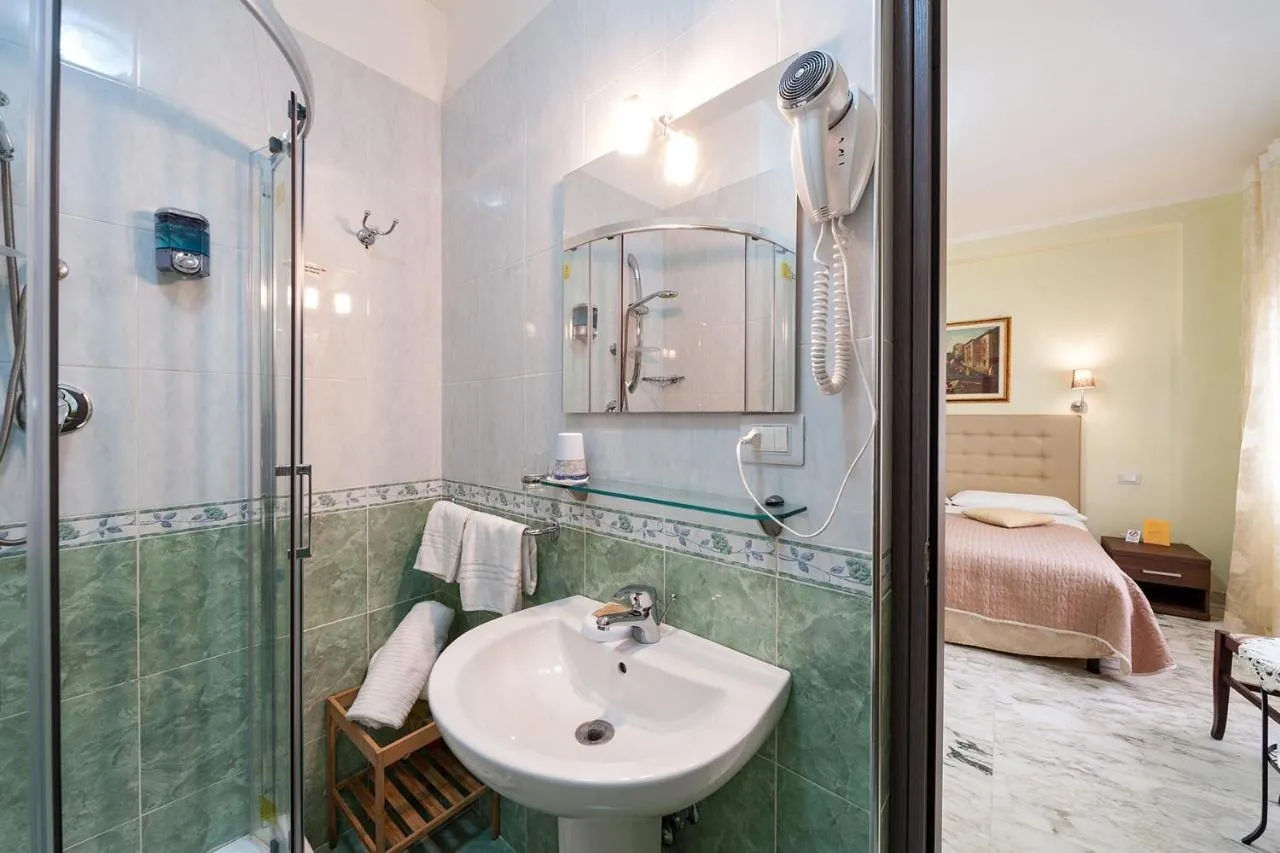 Bagno privato con doccia e, sullo sfondo, il letto